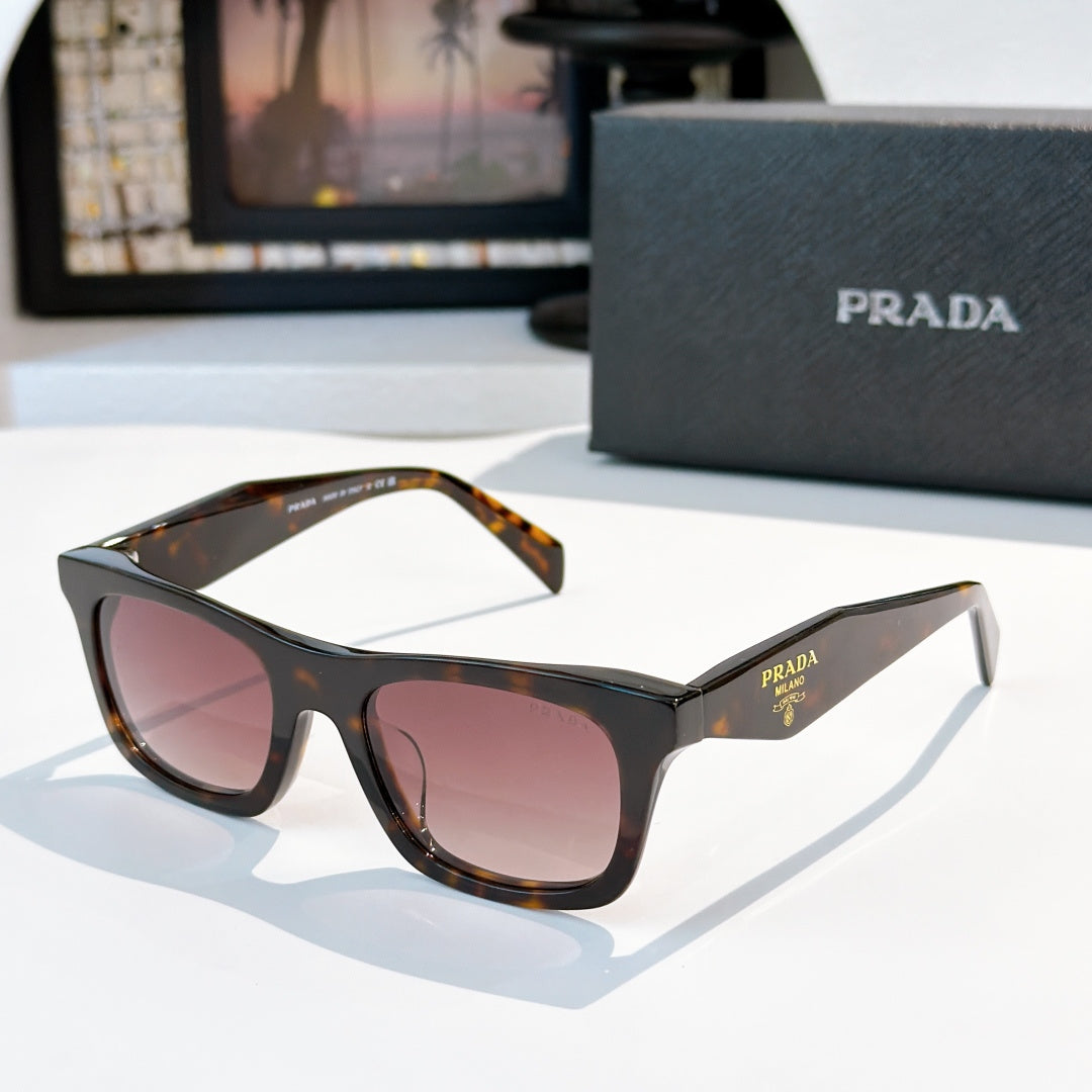 Black tortoiseshell cat-eye sunglasses with pink gradient lenses and Prada logo