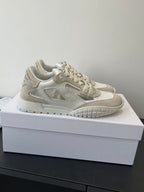 Cream lace-up sneaker with side logo detail, perforated trim, and grippy outsole
