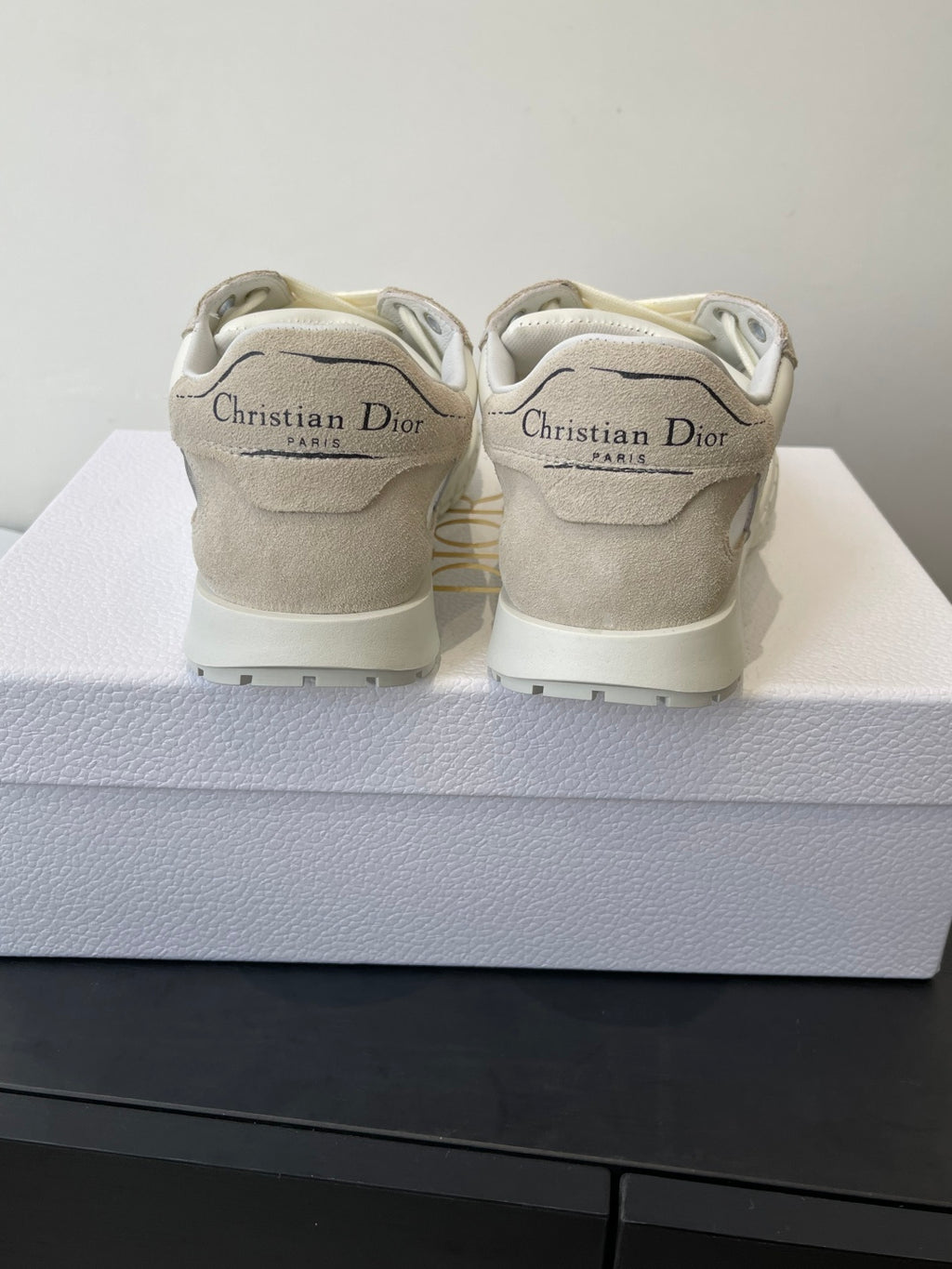 Cream lace-up sneakers with Dior branding on the heel counter, pair on box
