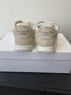 Cream lace-up sneakers with Dior branding on the heel counter, pair on box