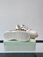 White sneaker outsole with hex tread pattern, shown from side on box