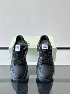 Front view of black lace-up sneakers with check panel detail and logo tag