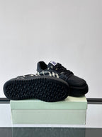 Black sneaker showing tread outsole and check panel side detail