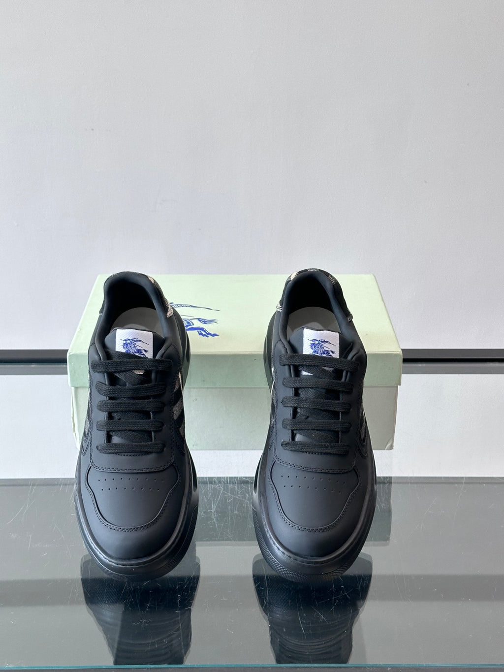 Dark leather low-top sneakers, black laces and plaid side detail