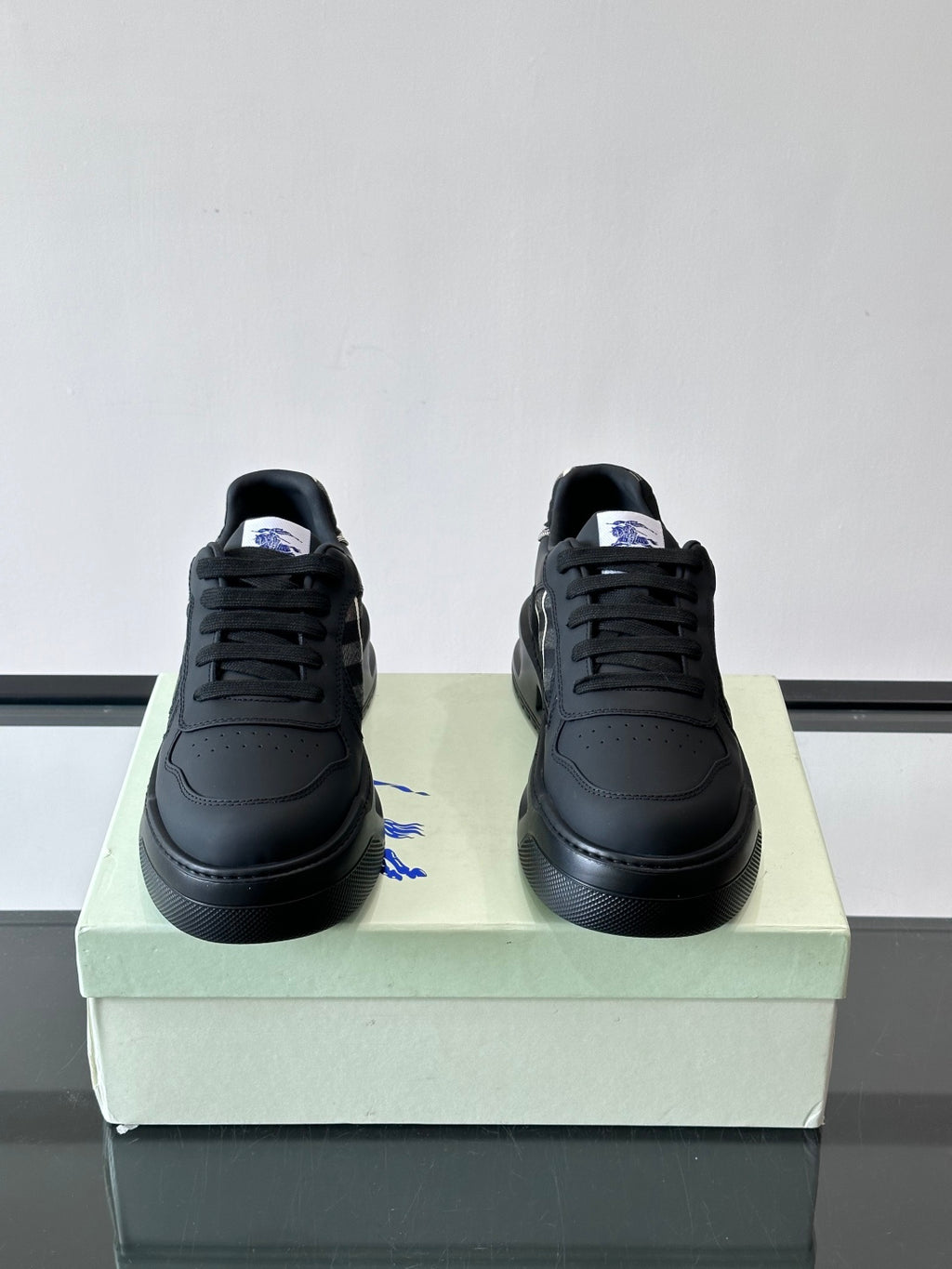 Low-top sneakers with dark leather, black laces, padded tongue, plaid accent
