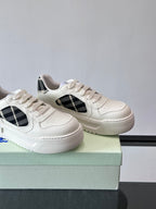 White leather-look sneakers, angled view, black plaid side panels