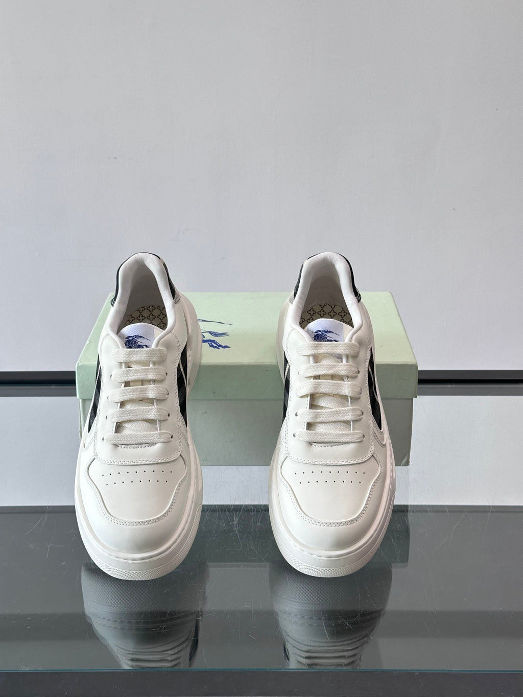 White leather-look sneakers with lace-up front and plaid accent near collar