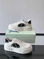 White leather-look sneakers with black plaid side panel and ridged sole