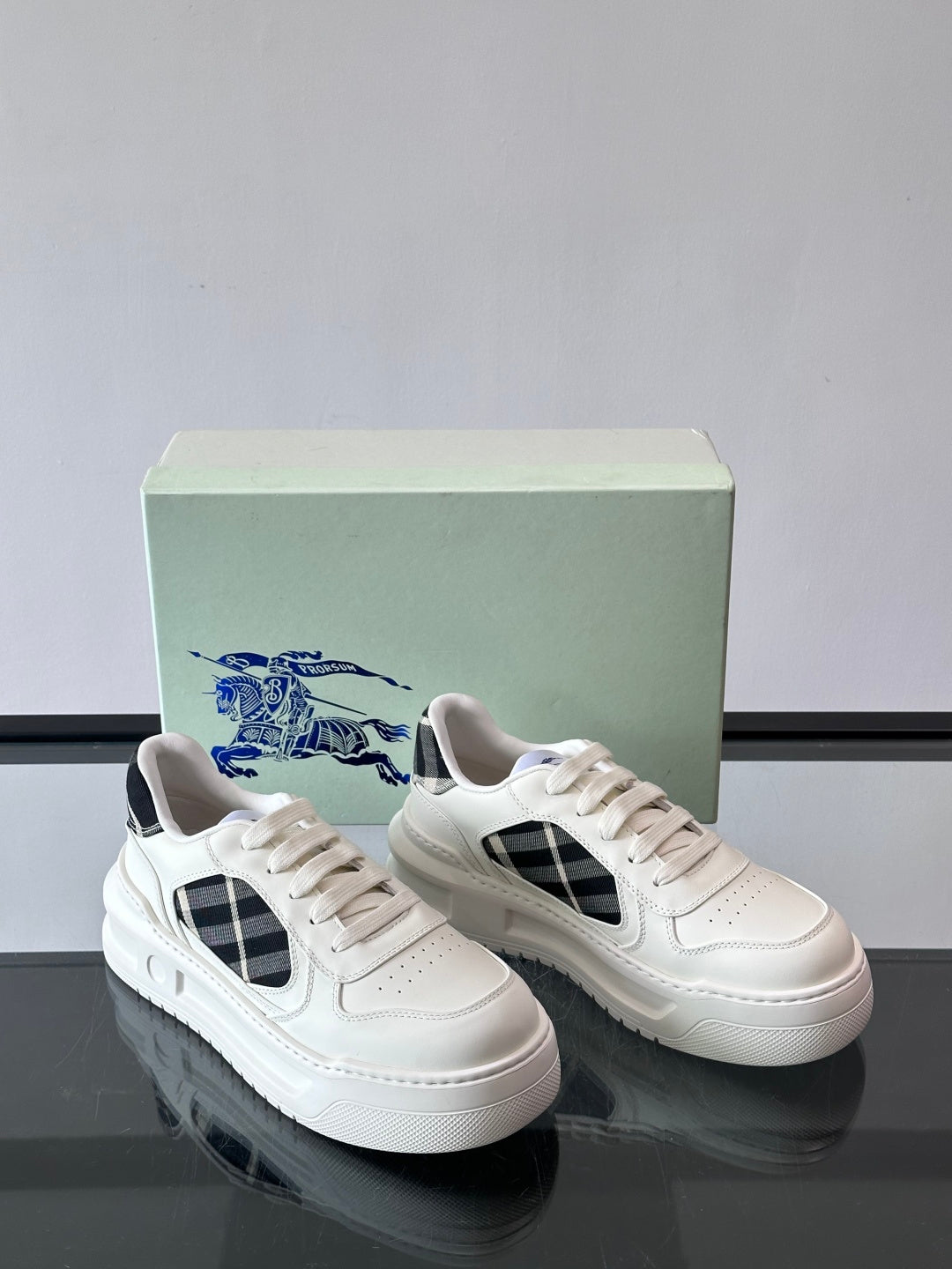Pair of white leather-look sneakers with black plaid side panels
