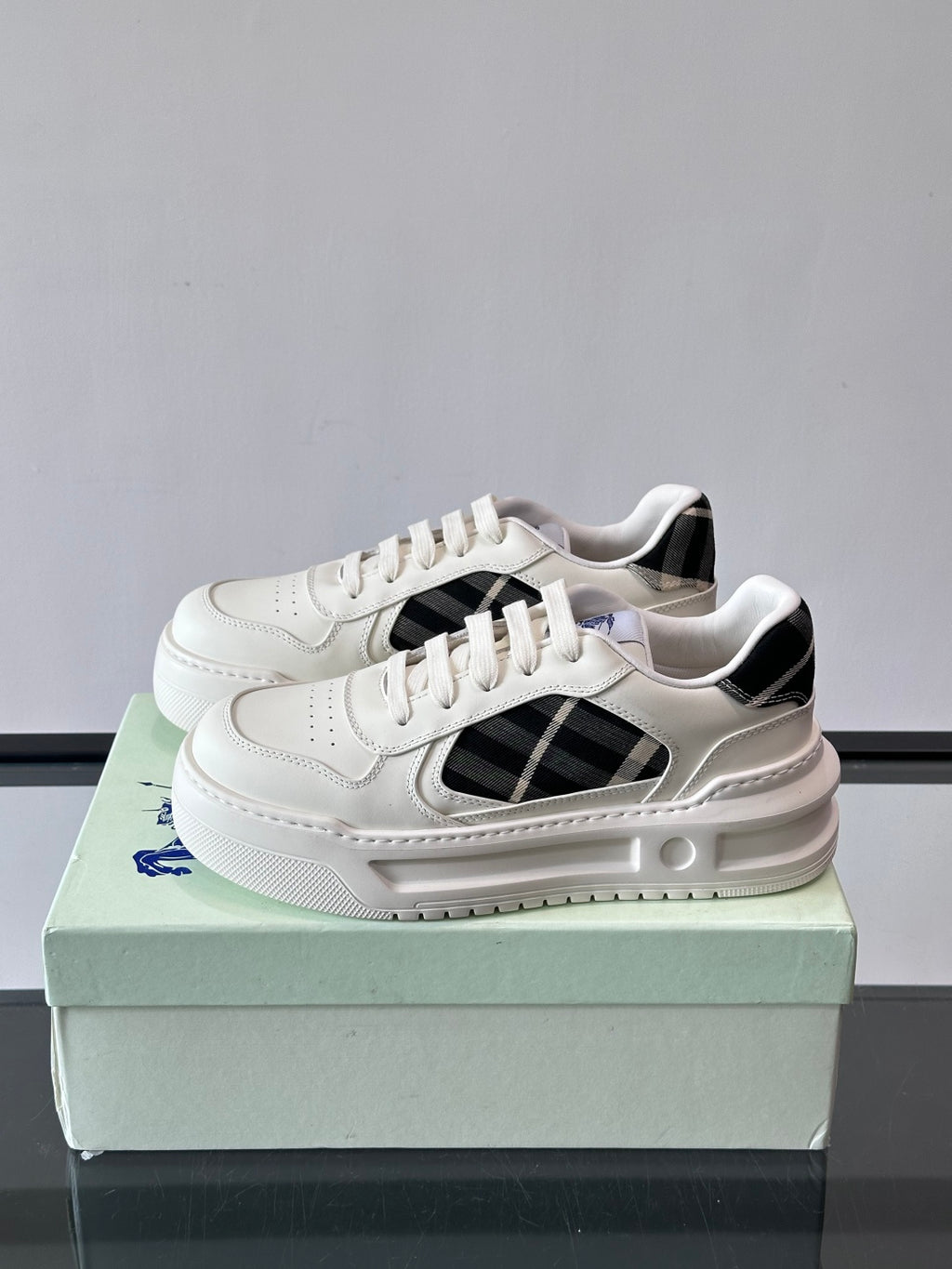 White leather-look sneakers with black plaid insert and lace-up closure