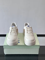 Pair of white lace-up sneakers with perforated toe and flat rubber sole
