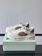 White lace-up sneakers showing plaid side insert and cushioned midsole