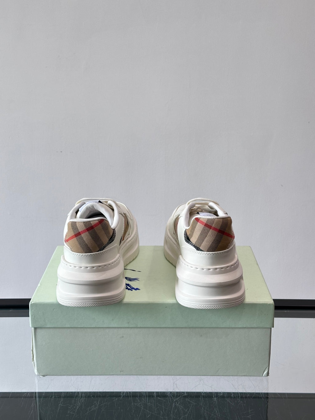 Back view of white sneakers with plaid heel lining and cushioned collar