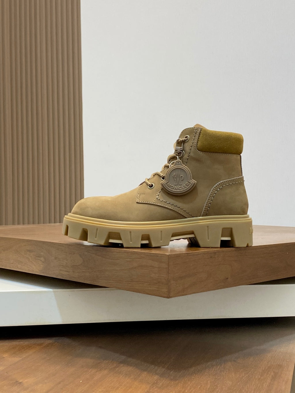 Suede lace-up ankle boots with round logo patch and chunky tread sole.