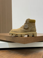 Tan suede lace-up ankle boots with round logo patch and lug sole