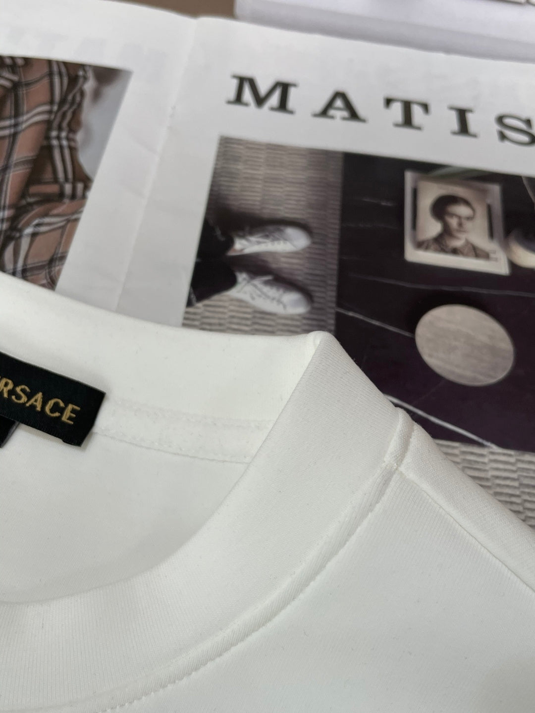 White crewneck sweatshirt neckline close-up with black neck label