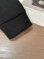 Black crewneck sweatshirt sleeve and hem detail with ribbed cuff