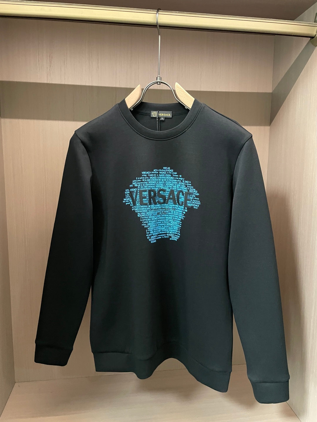 Black crewneck sweatshirt with blue text face graphic on chest