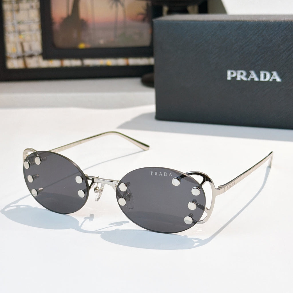 Prada sunglasses with round dark lenses and gold-tone studded frame, slim metal arms