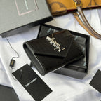 Black croc-textured small leather bag with gold YSL logo, shown at an angle