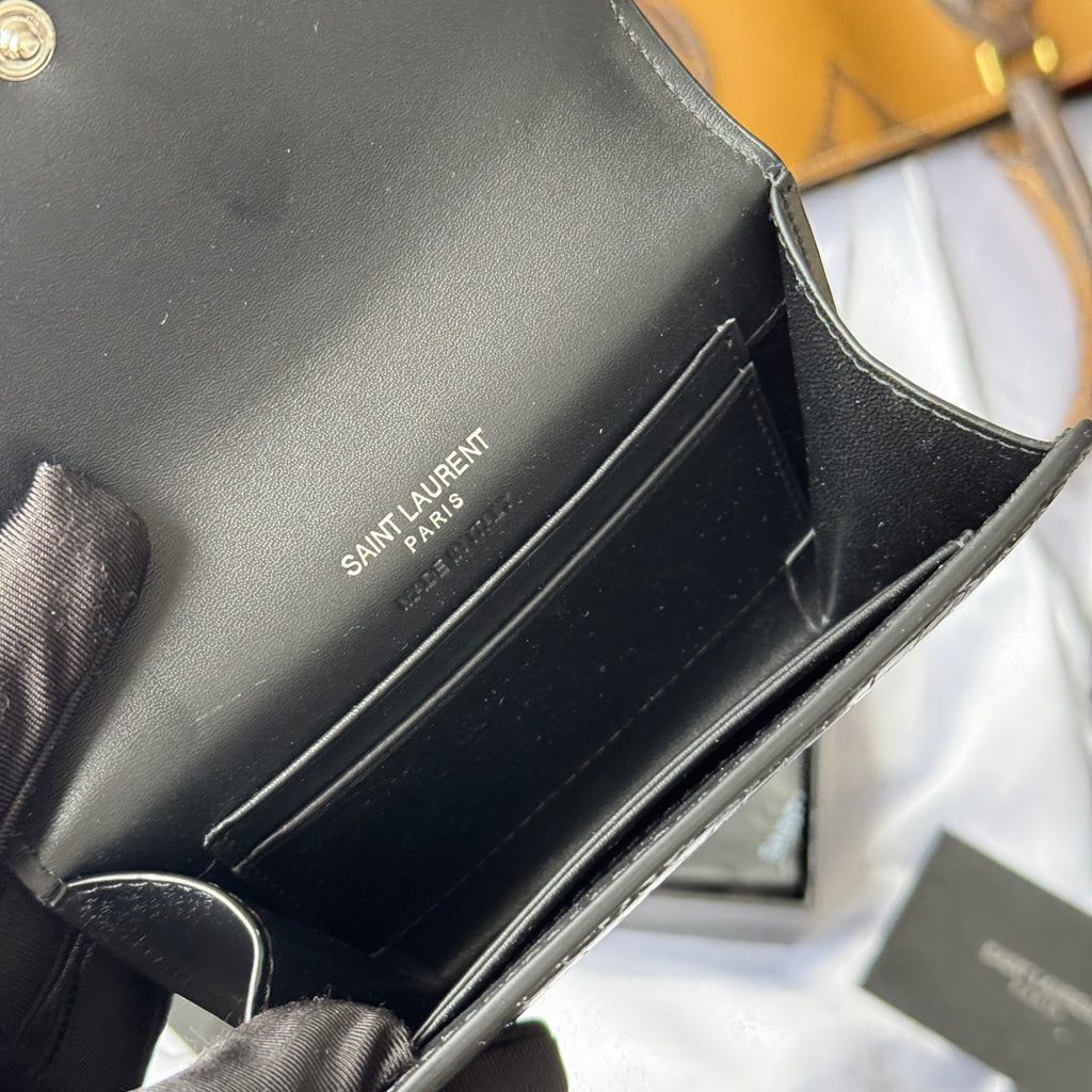 Black small leather bag interior with SAINT LAURENT PARIS text on the lining