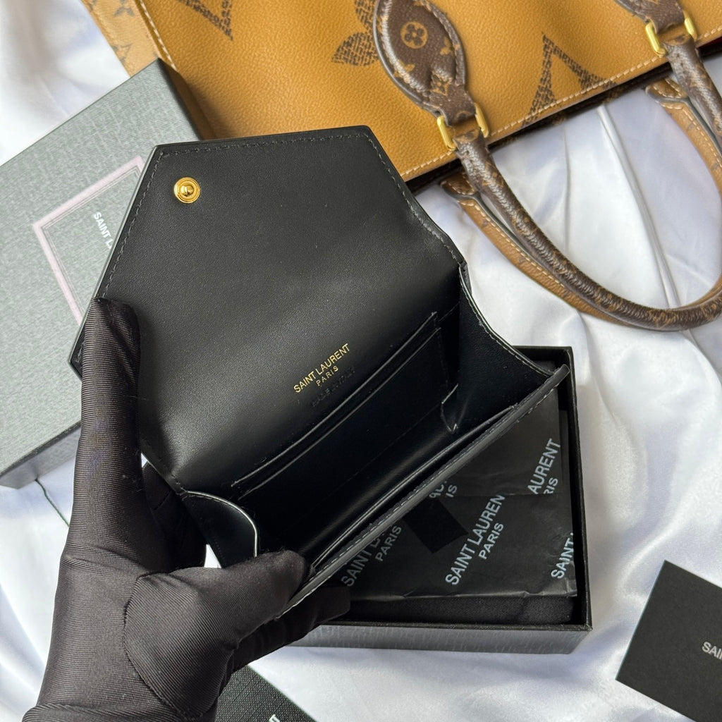 Black small bag with croc front, opened flap shown in gloved hand
