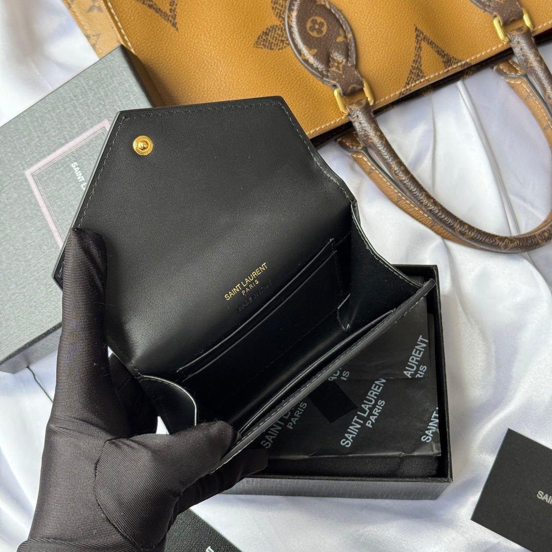 Black small bag with croc front, opened flap shown in gloved hand