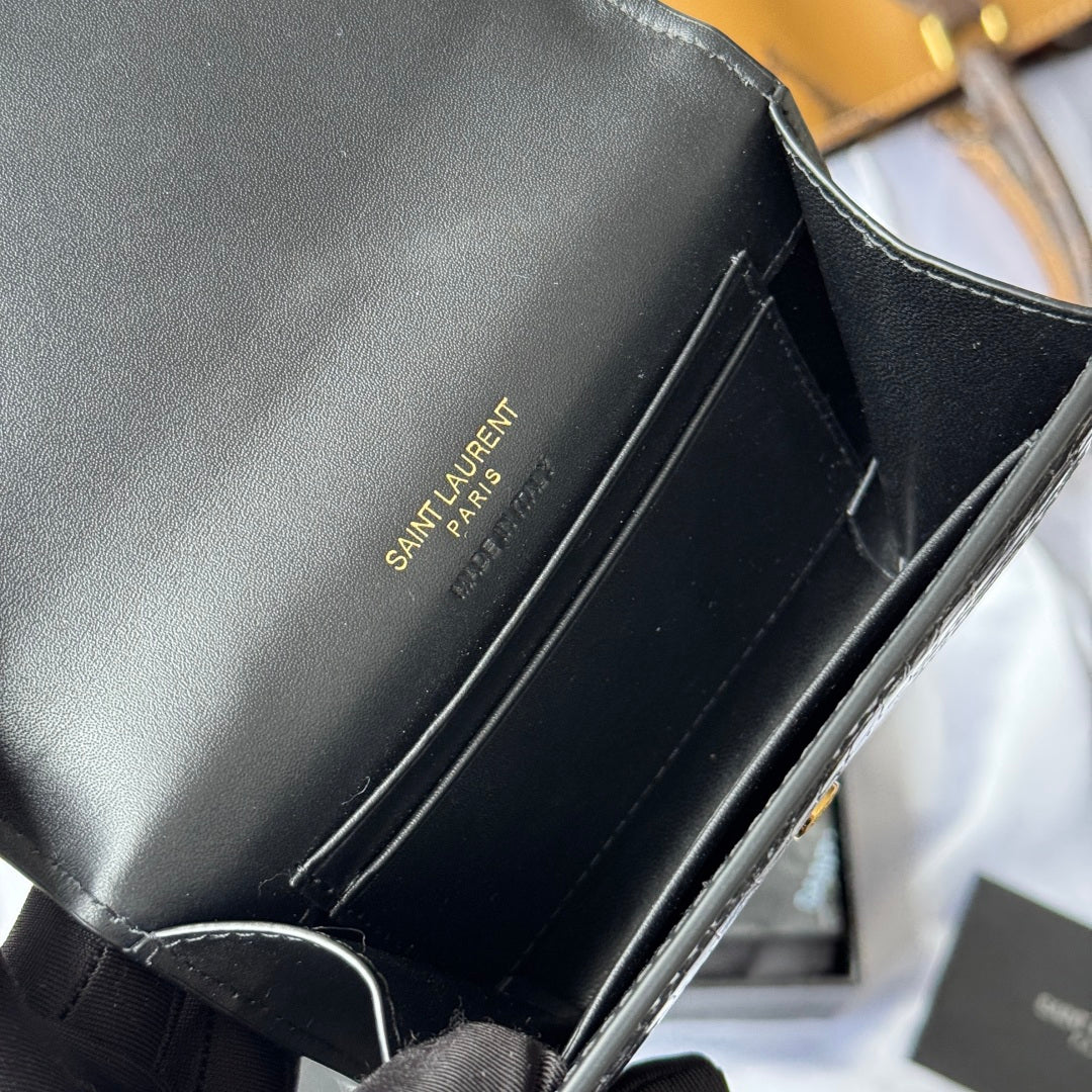 Black small bag interior with stitched edges, held open in gloved hand