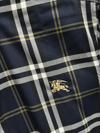 Navy plaid long-sleeve shirt with gold horse logo centered on the front