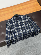 Navy plaid long-sleeve button-up shirt hanging on a wooden hanger