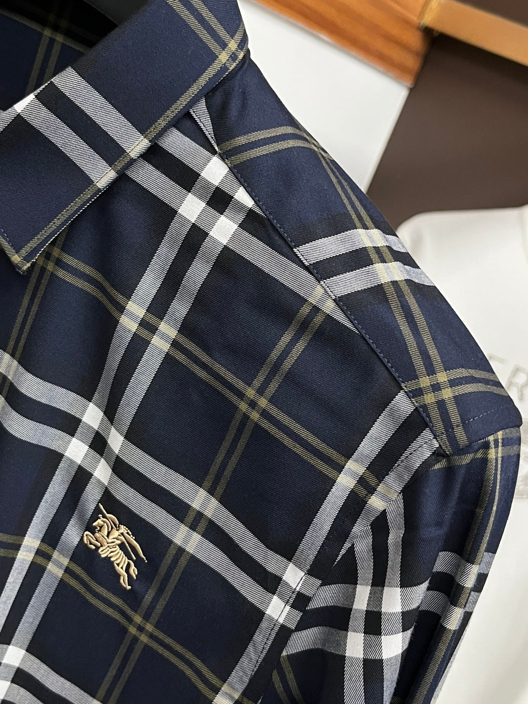 Navy plaid long-sleeve shirt with gold horse logo on the front