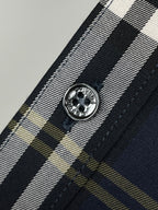 Navy plaid shirt button close-up with round metal-style front button