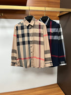 Two Burberry plaid long-sleeve button-front shirts on hangers: light and dark colorways