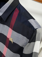 Long-sleeve plaid shirt sleeve with black, gray, and red check and gold logo