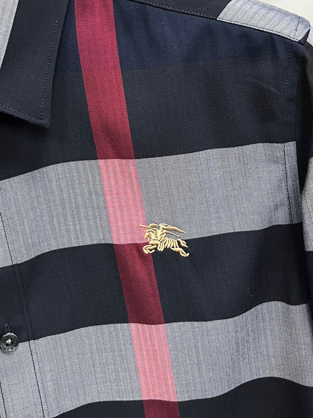 Long-sleeve plaid shirt with gold embroidered emblem on black, gray, and red check