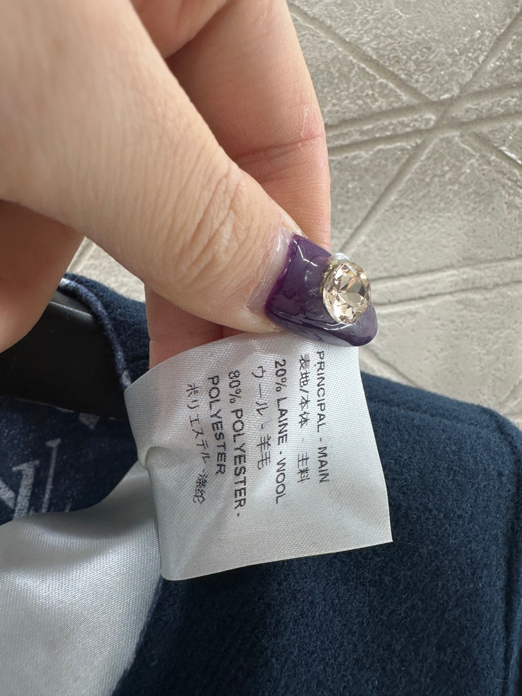 Clothing care label inside coat showing fabric percentages and country info