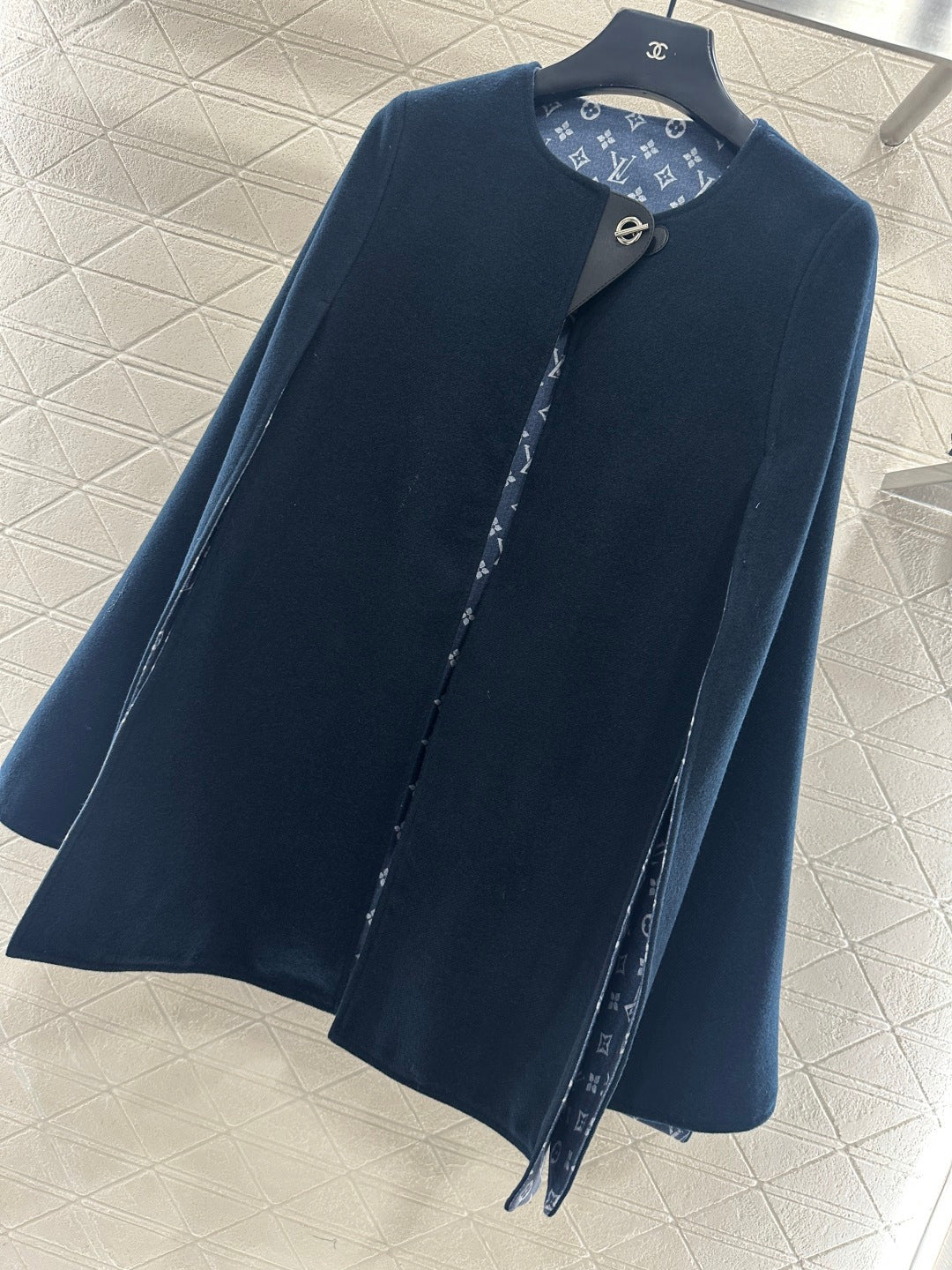 Navy long coat with stand collar and monogram-lined front placket