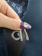Metal key ring clasp attached to dark fabric panel