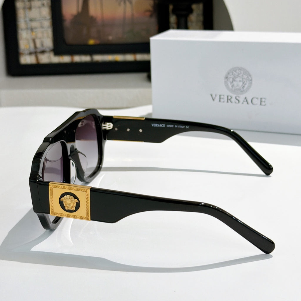 Side view black cat-eye sunglasses with gold logo plaque and tinted lenses