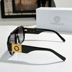 Side view black cat-eye sunglasses with gold logo plaque and tinted lenses