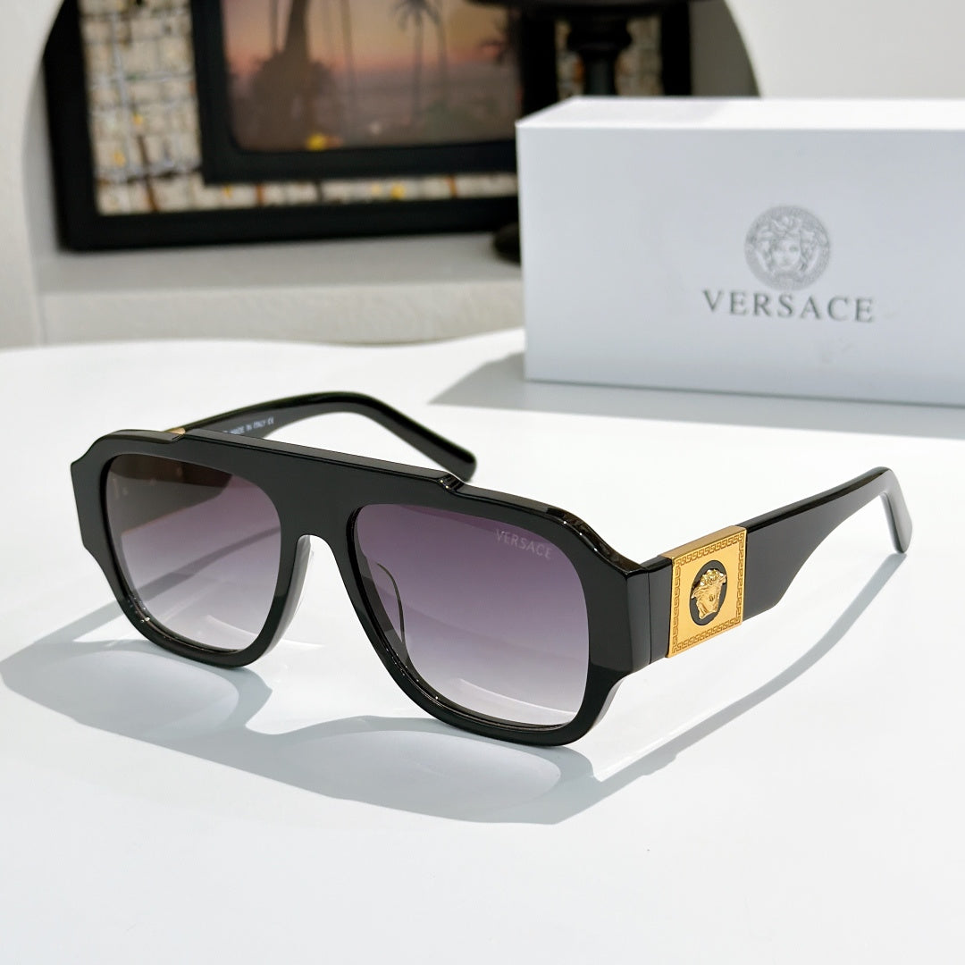 Black cat-eye sunglasses with purple-tinted lenses and gold logo plaque