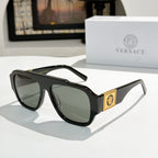 Black cat-eye sunglasses with dark lenses and gold logo plaque on the temple