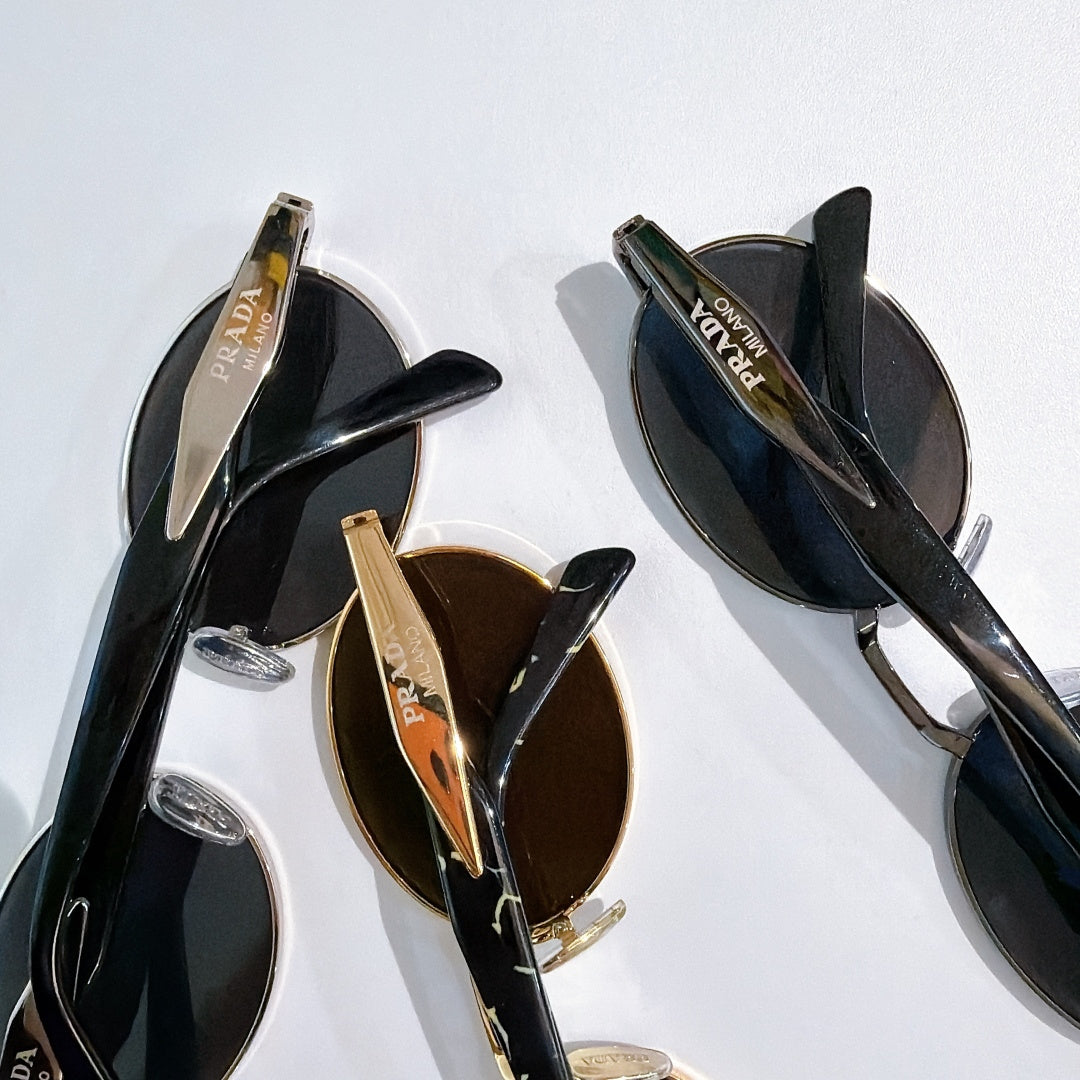 Prada sunglasses side view with dark tinted lenses and gold-tone detailing