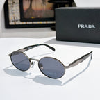 Prada round sunglasses with gold-tone frames and blue-gray tinted lenses