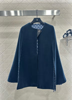 Navy long coat with stand collar and side snap closure, monogram-lined placket