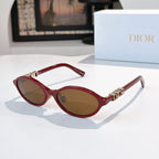 Sunglasses with red frames, gold logo detail, brown-tinted lenses