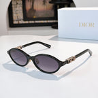 Sunglasses with black frames, gold logo detail, purple-tinted lenses