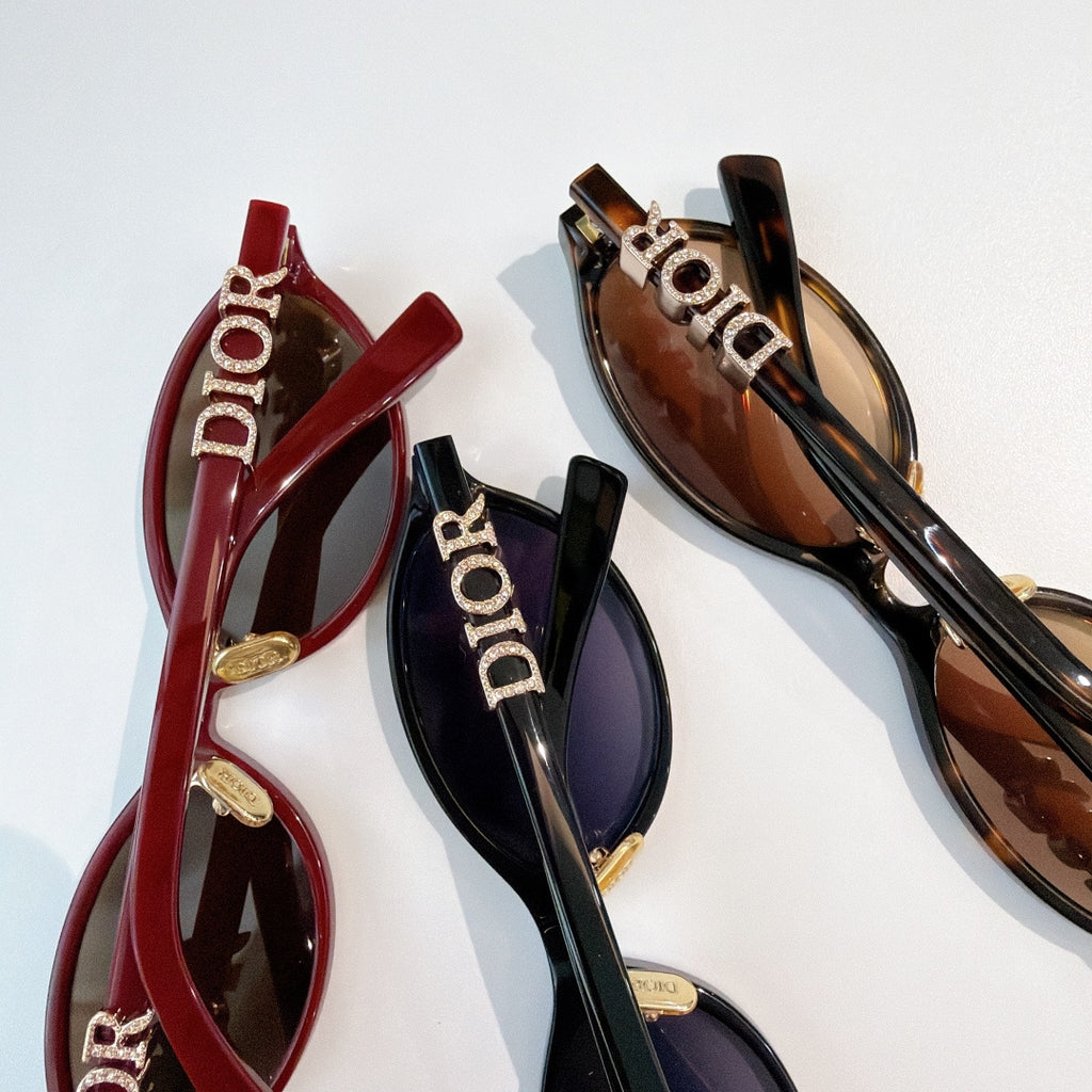 Sunglasses close-up: red, black and brown frames with gold Dior logos