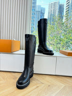 Black leather knee-high boots with buckle and thick tread sole