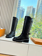 Black knee-high leather boots with two buckle straps and low heel